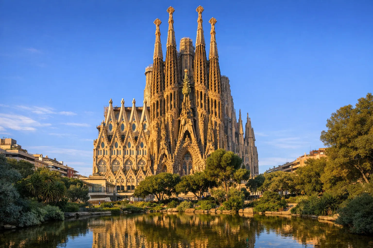 The ornate towers of the Sagrada Família basilica in Barcelona against a clear sky.