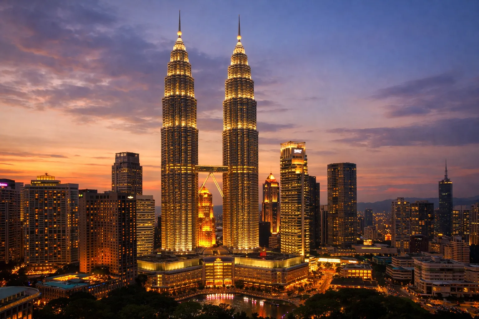 The illuminated Petronas Twin Towers connected by a skybridge, glowing against the dusk sky.