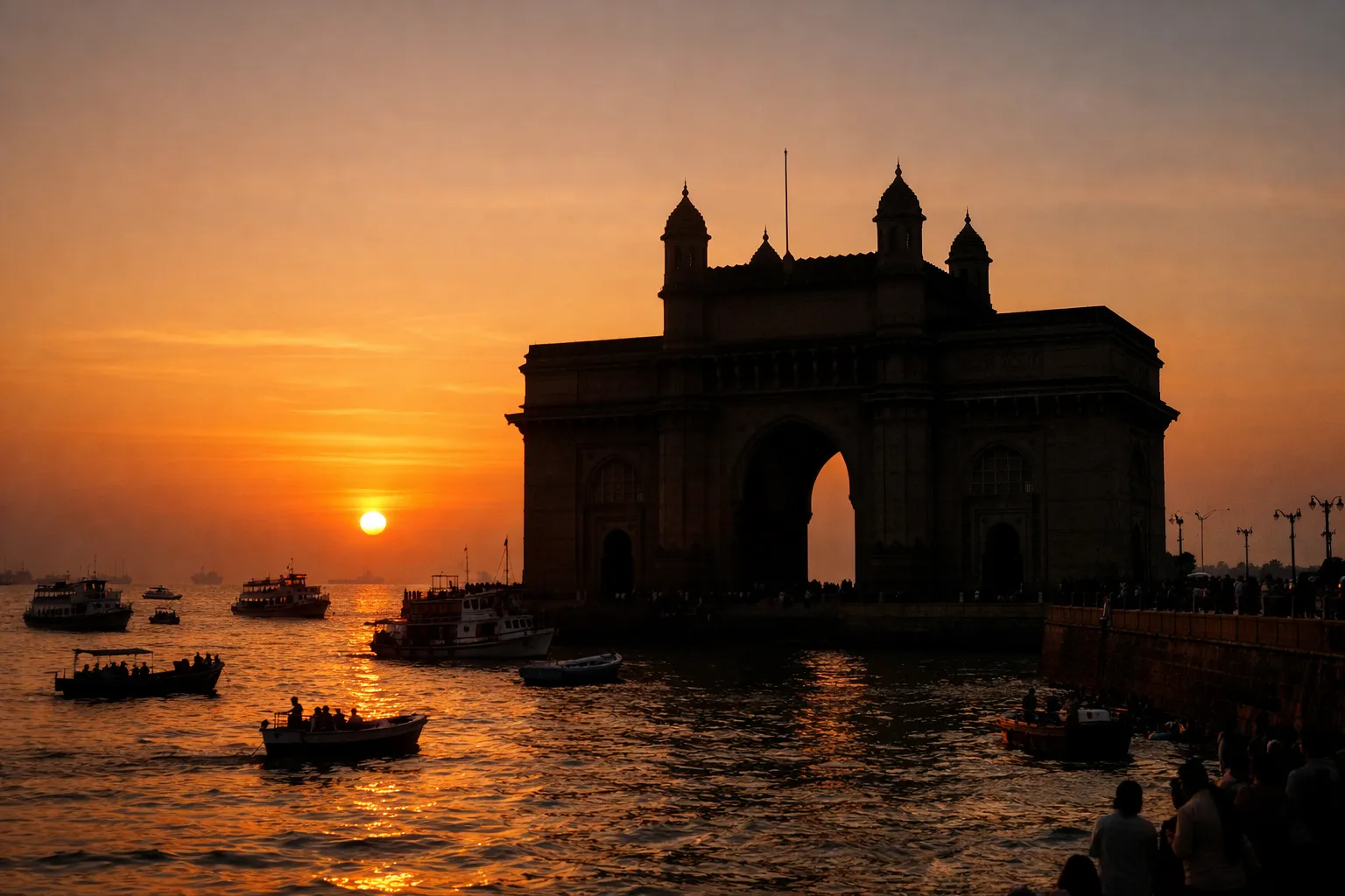 The Gateway of India arch silhouetted against a warm sunset over the Arabian Sea.