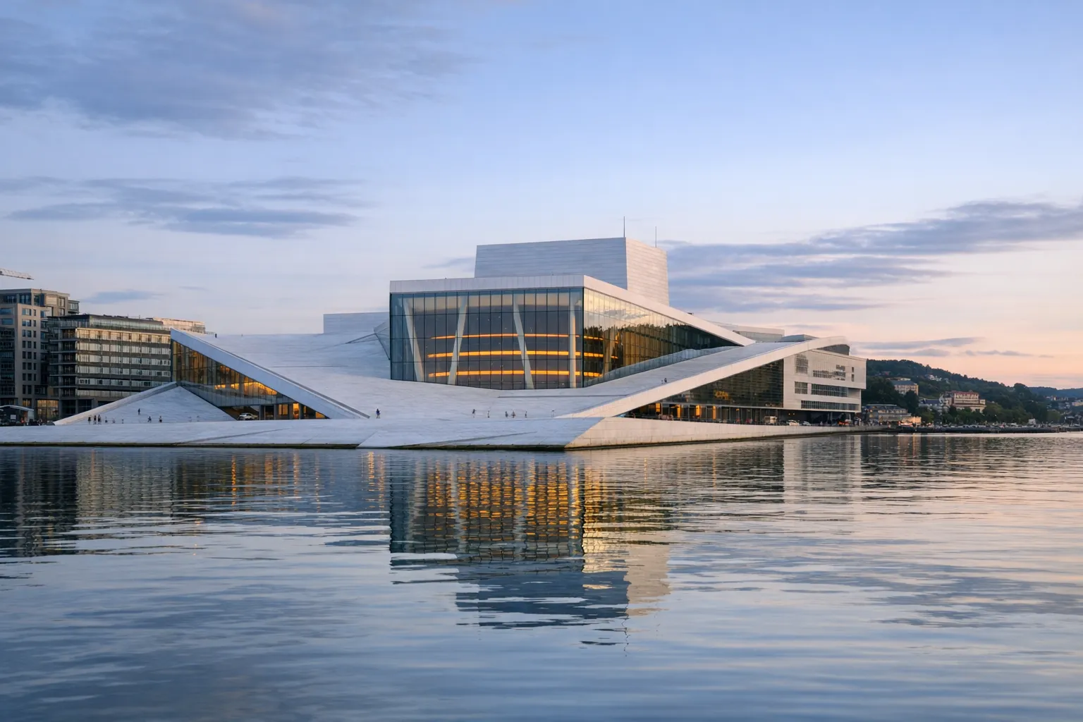 The white, angular Oslo Opera House at the edge of the fjord in soft daylight.